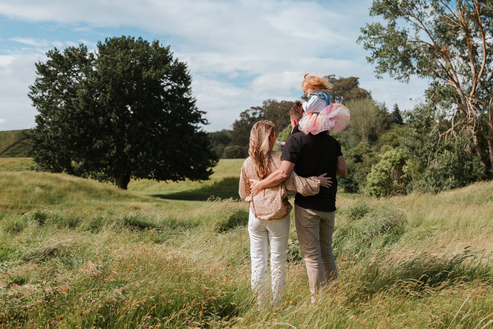 Jonathan's family walking through long grass, daughter on his shoulders